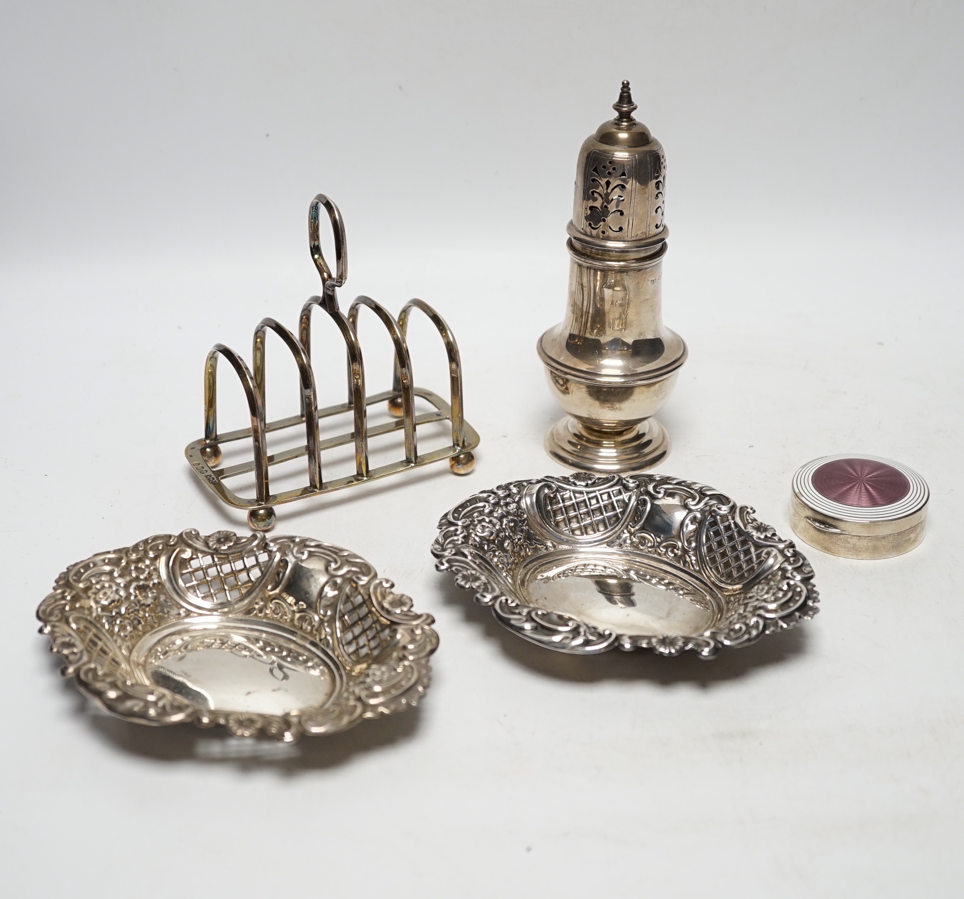 A 1930's silver sugar caster, 16.2cm, a silver five bar toastrack, two silver bonbon dishes and an early 20th century German 900 standard and two colour enamel circular pill box and cover, by Louis Kuppenheim (enamel a.f
